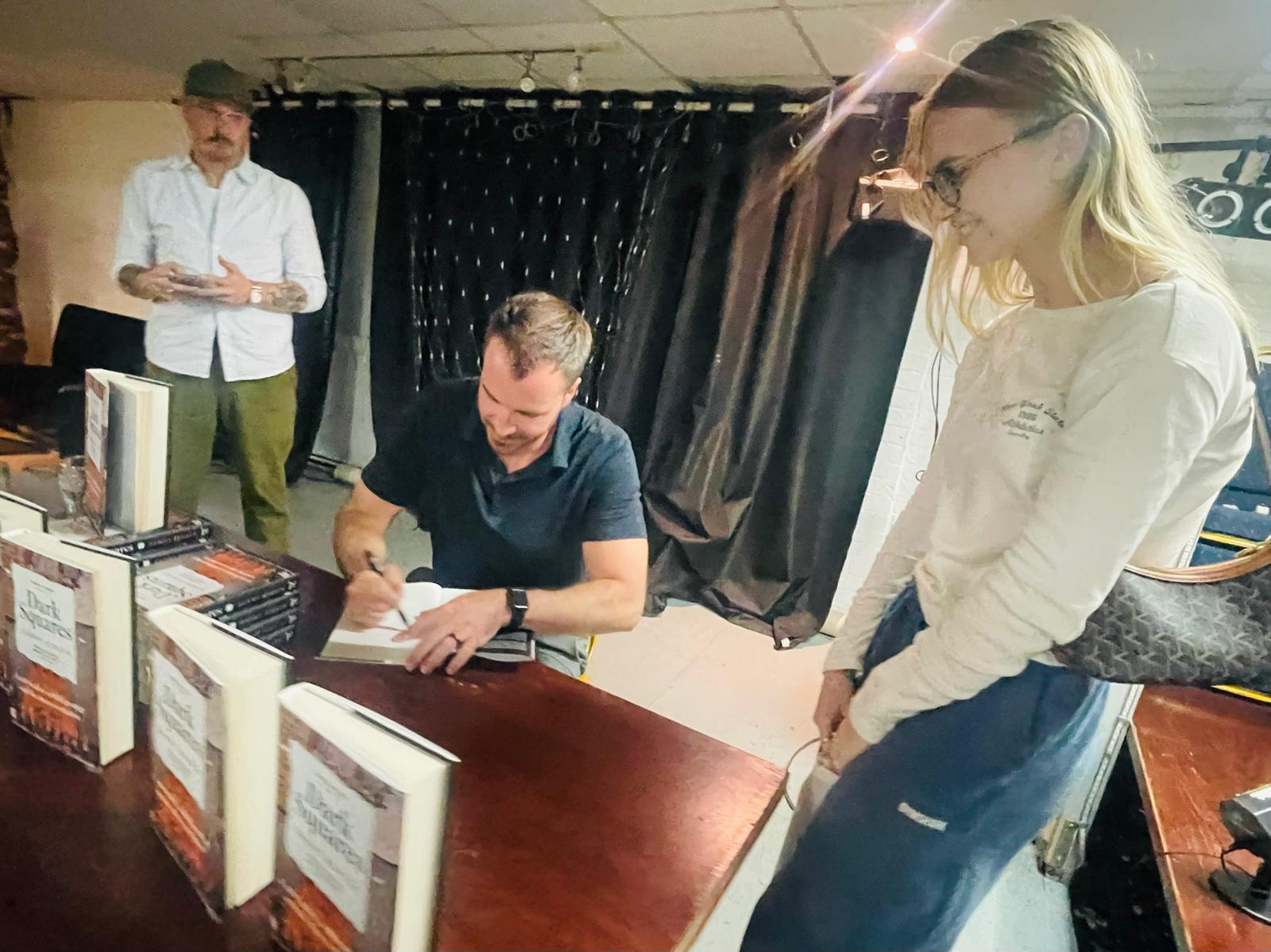 Danny Rensch signing copies of his book.